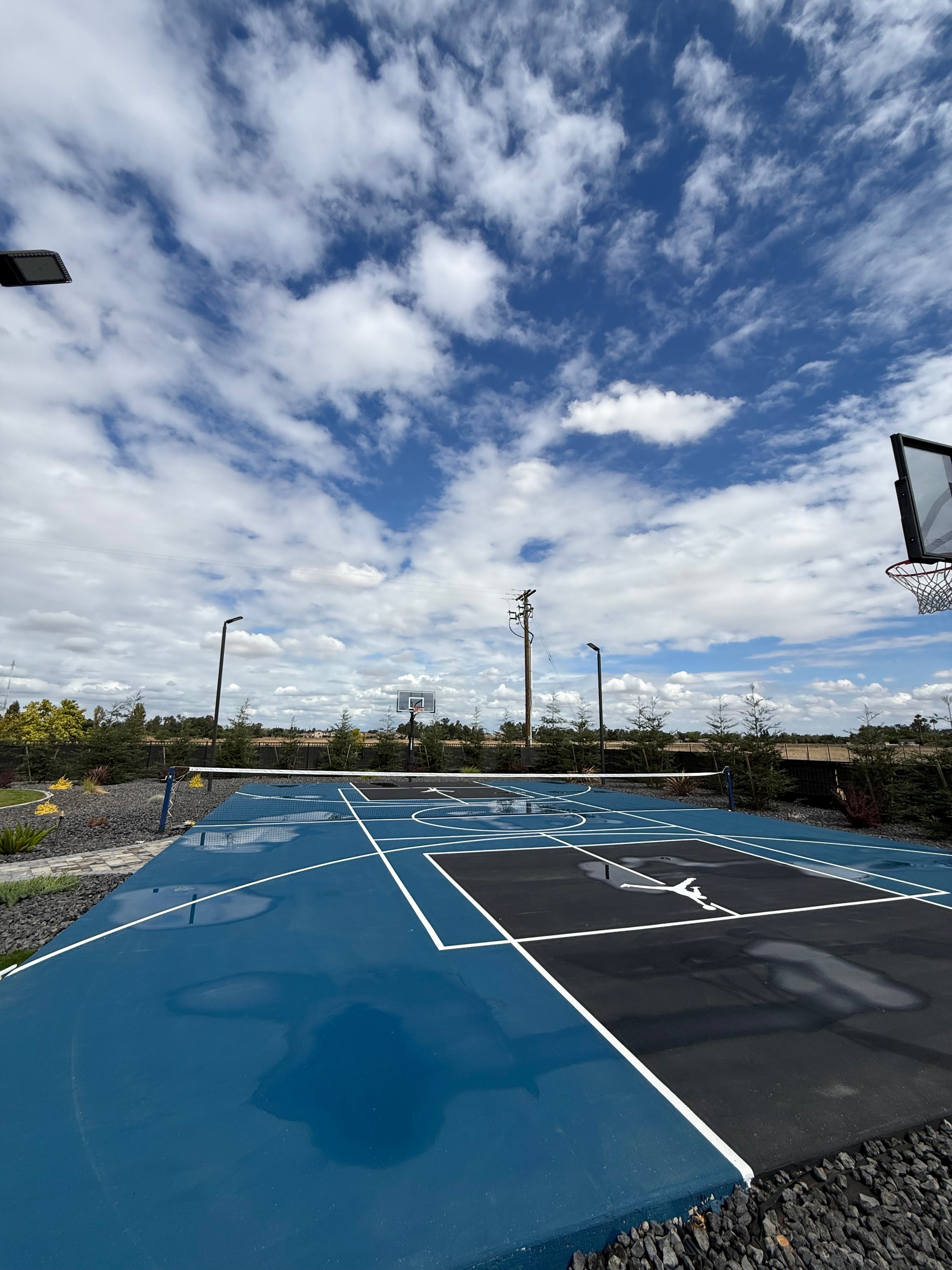 Freshly cleaned outdoor basketball court with blue and black surfaces