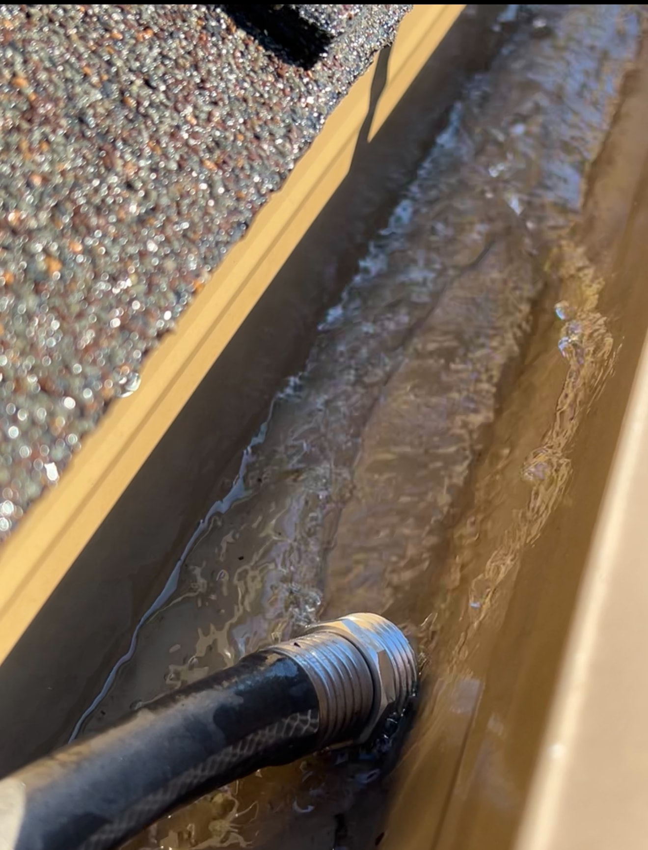 Gutter being cleaned with flowing water
