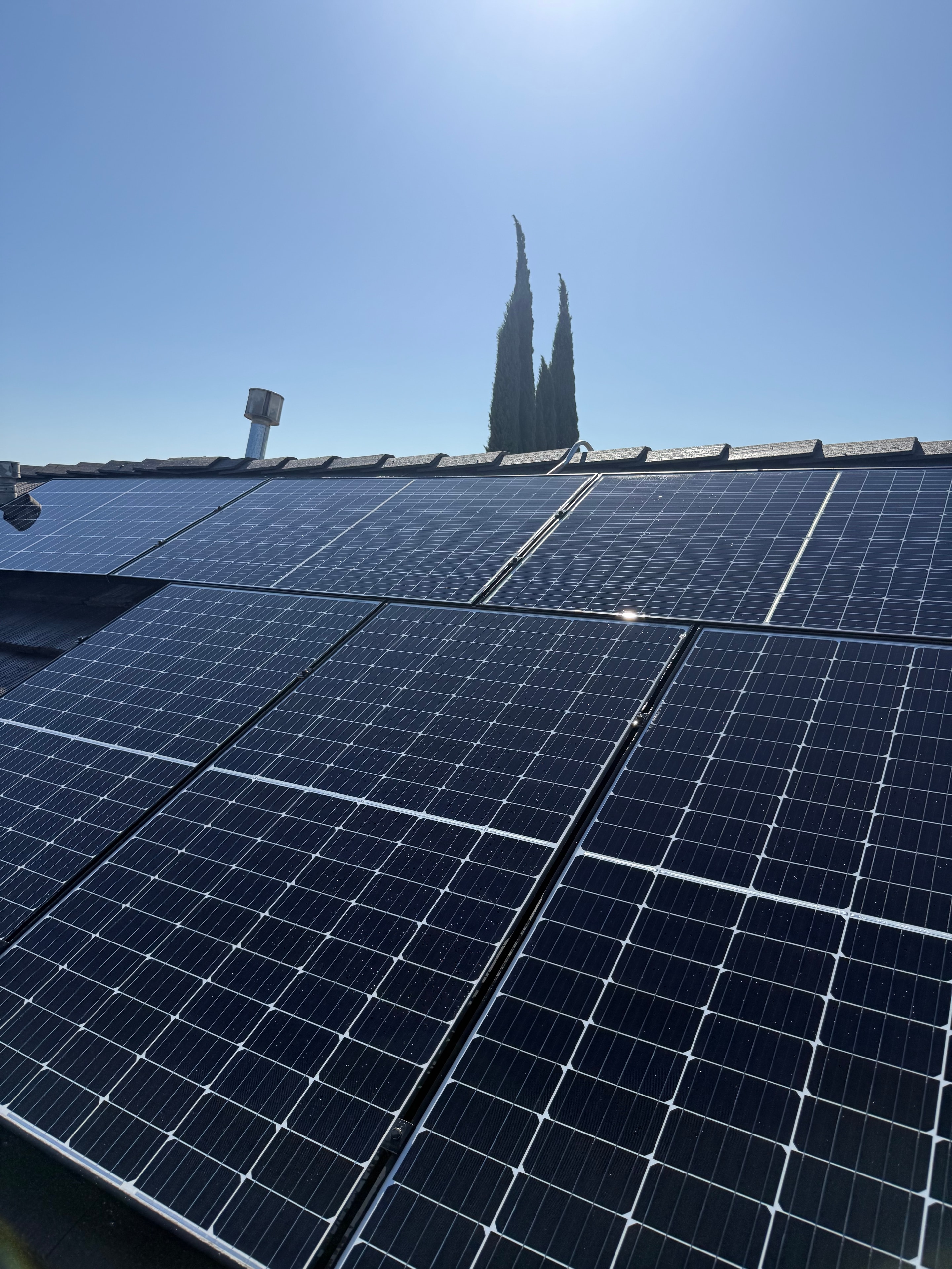 Residential solar panels against a clear blue sky